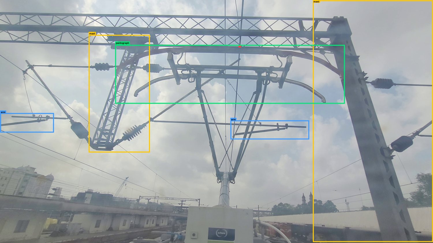 Labelled railway frame, Ahmedabad: Portal mast, cantilever arms and the pantograph under a gantry.